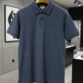 Blue polo shirt on a hanger in a store setting